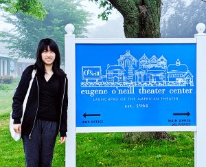 Alison Qu stands in front of the Eugene O'Neill Theater Center sign