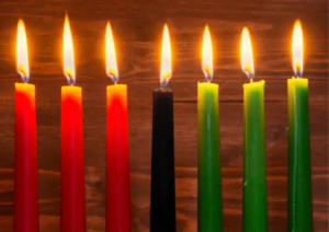 Kinara with seven candles, three red candles on the left, three green candles on the right, a black candle in the center.