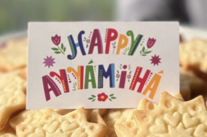 A sign among baked goods, "Happy Ayyam-i-Ha"
