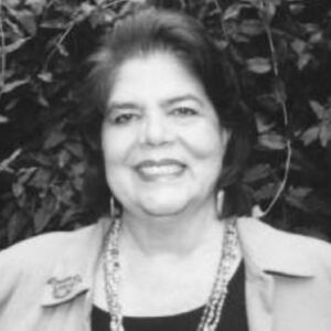 Photograph of Wilma Mankiller with plants behind her.