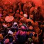 Crowd of celebrators covered in colorful powders celebrating Holi, the festival of color.