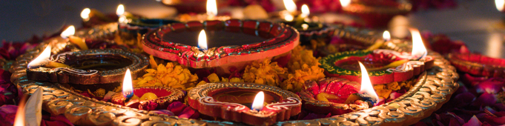 Photograph of candles arranged in a circle amongst flowers representing cultural festivals of light.