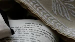Jewish prayer shawl with prayer book with passage to remember the dead.