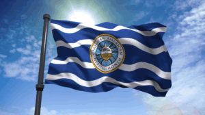 Caribbean American Heritage Month Flag against blue sunny sky.