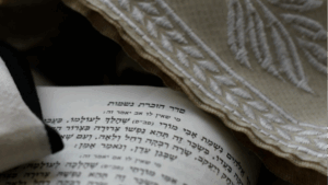 Jewish prayer shawl with prayer book with passage to remember the dead.