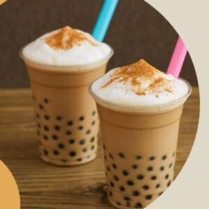 Two boba cups, one with a blue straw and one with a pink straw