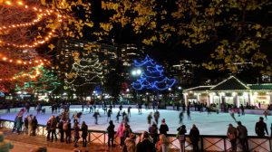 Ice skaters enjoying winter break on the ice rink at night in the Boston Common Frog Pond.