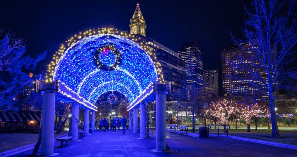 Blue lights, a wreath, and garland on the trellis in Boston's Columbus Park, lit for the majority of the winter season.