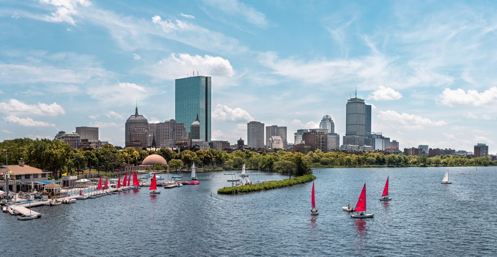 View of sailboats on the Charles River with city buildings in the background