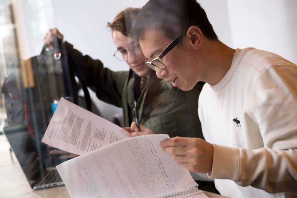 Students reviewing the syllabus for the fall semester and making notes.