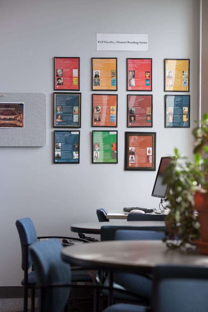 Image of Writing Literature and Publishing graduate student lounge tables and computer setup overlooking the windows with views of the Boston Common 