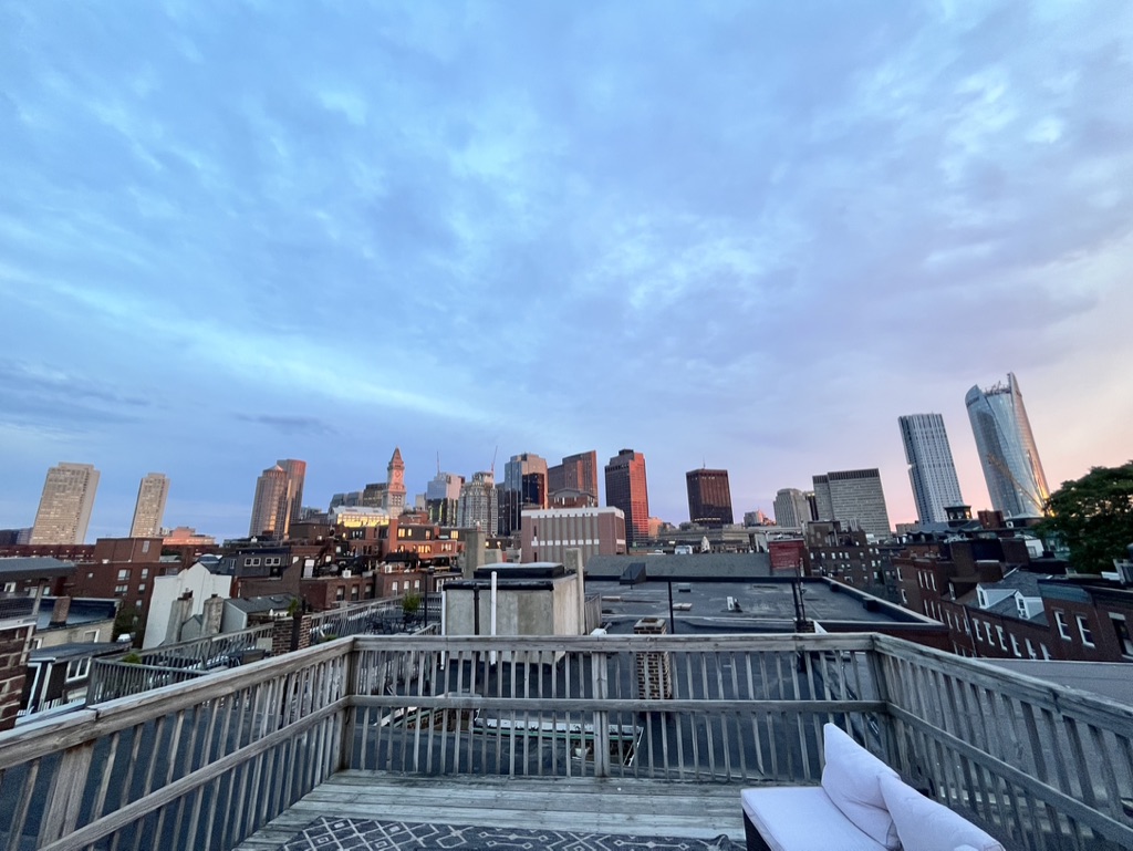 Image of the Boston skyline taken from a rooftop at sunset.