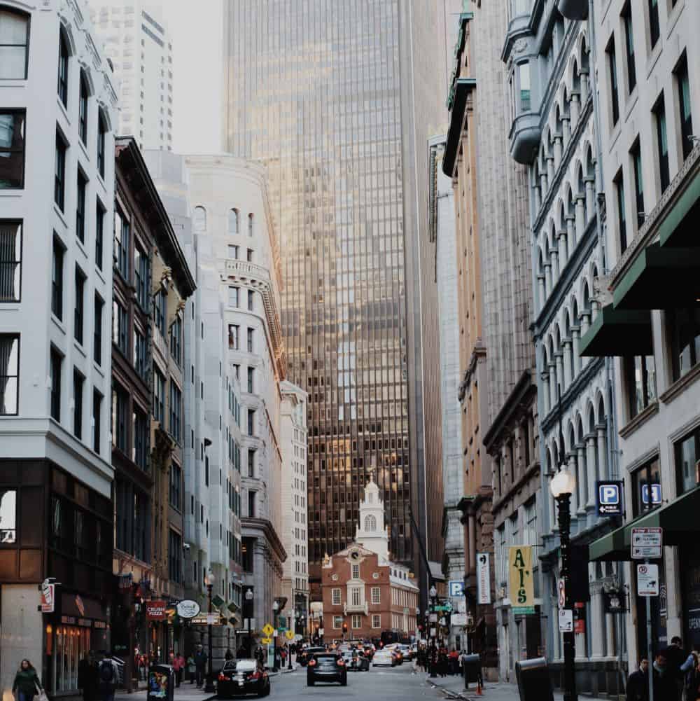 Cars drive past the Old State House in downtown Boston