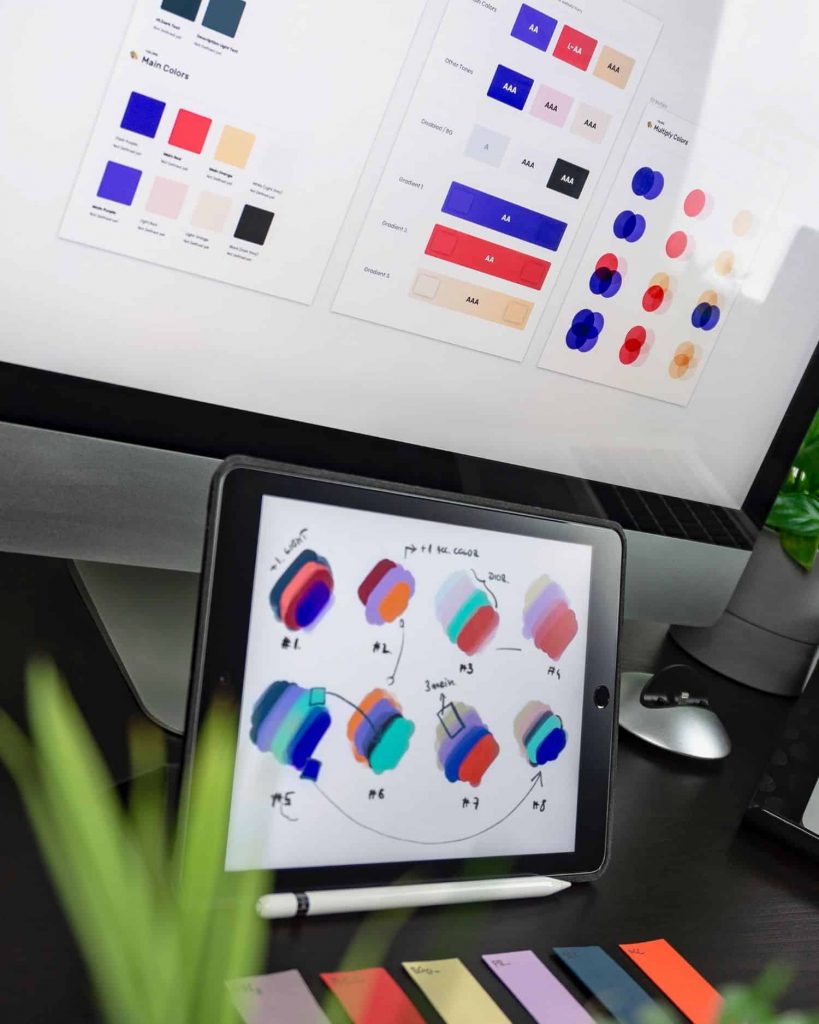 Computer and tablet screens showing different color swatches for a creative project