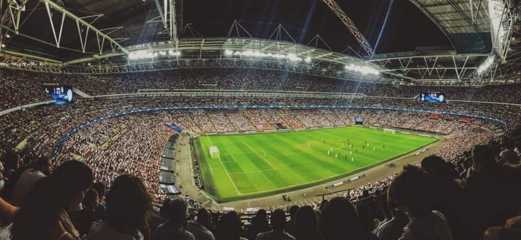 A soccer game viewed from above with a full stadium