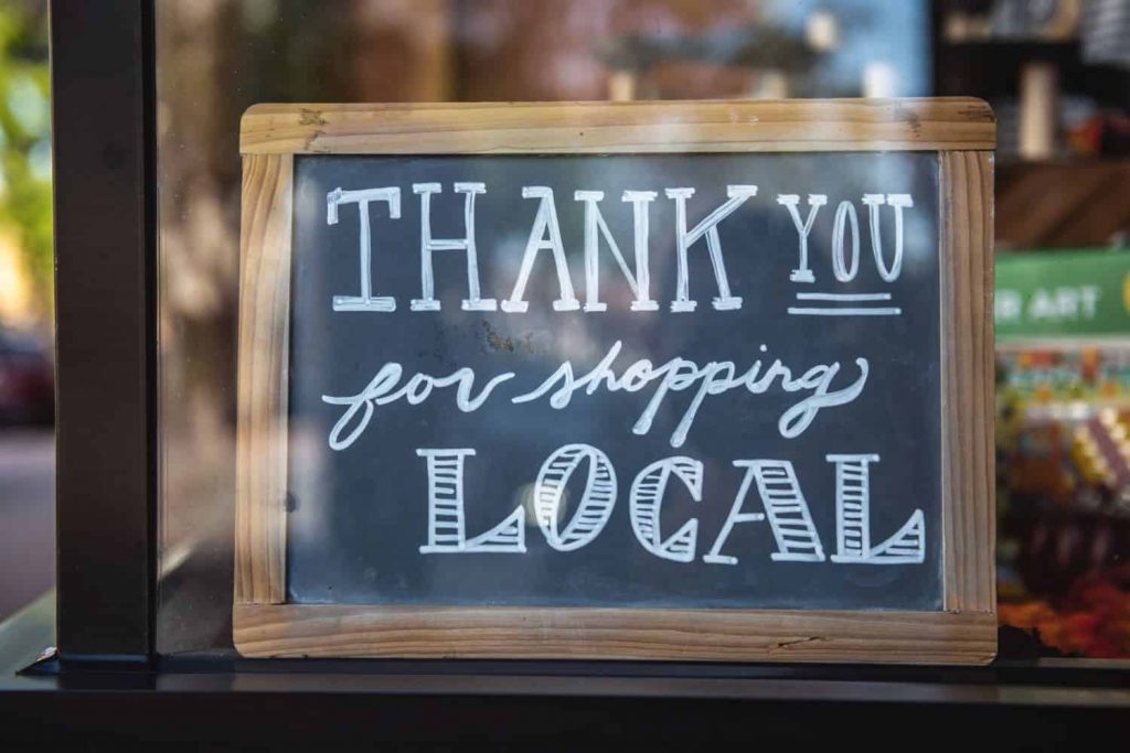A chalk art sign that says "Thank you for shopping local"