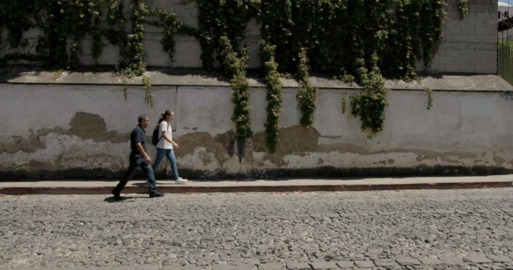 Isabel and her father walking on an empty street in Guatemala City
