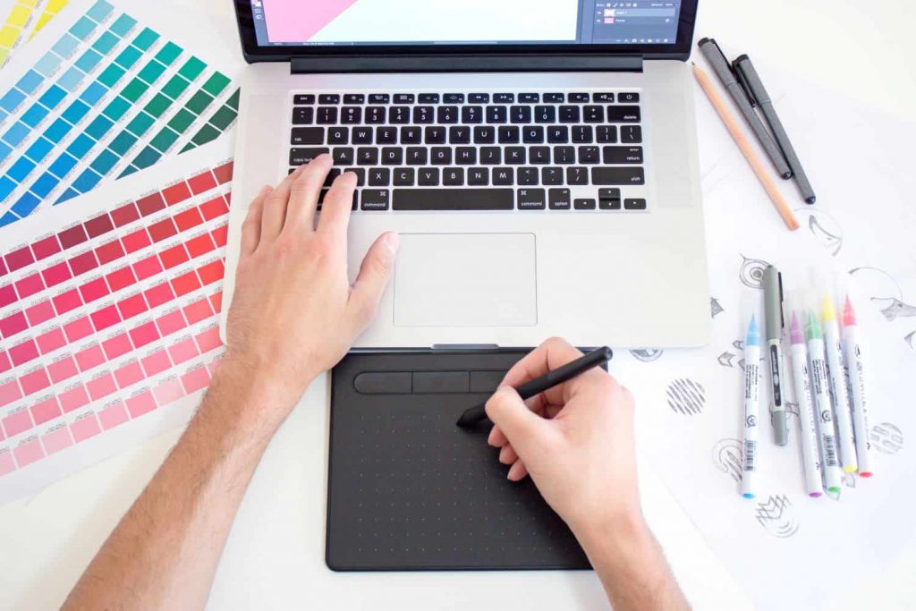 Art Director working at a laptop with color swatches and markers