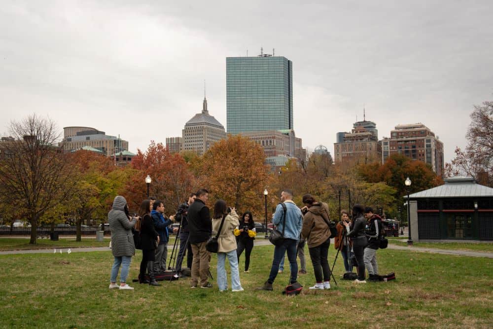 Students standing in the Boston Common, working together with film equipment