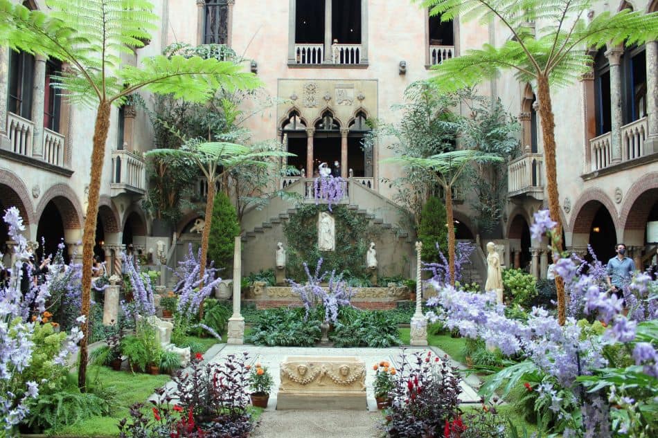 The Roman style garden inside the Isabella Stewart Gardner museum, full of flowers and greenery