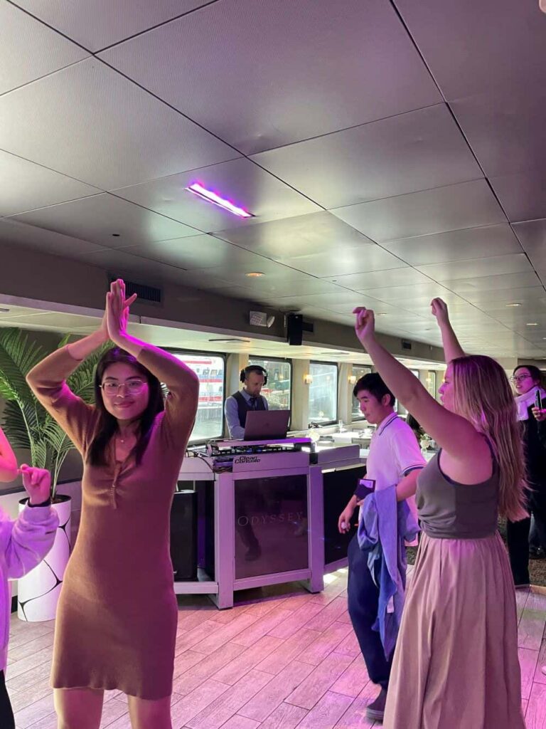 Students dancing while a DJ plays music on the lower level of a cruise ship for the GSA's Boston Harbor Lunch Cruise 