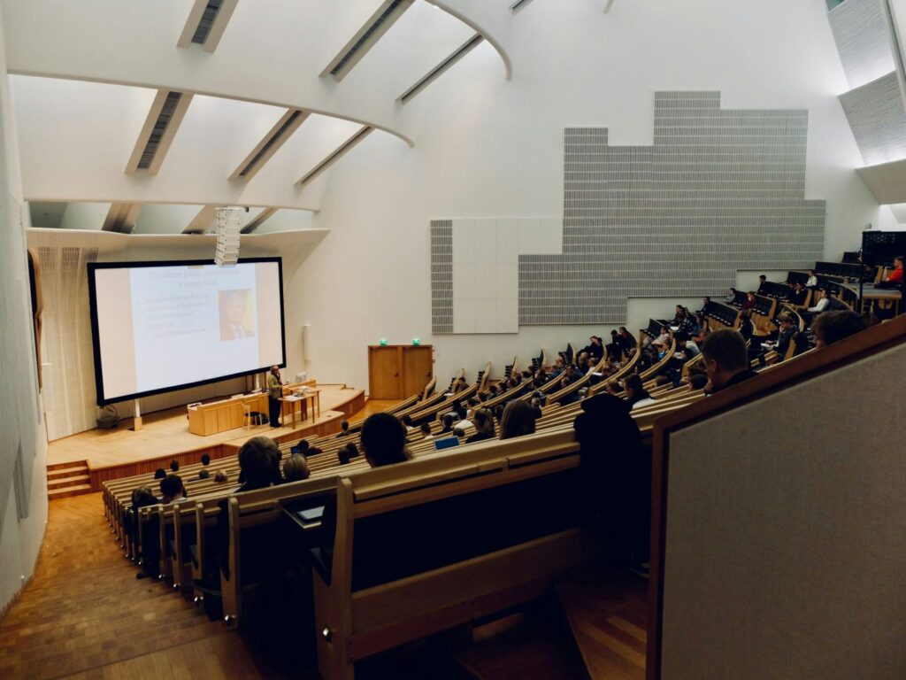 Students sit in a lecture hall listening to class material