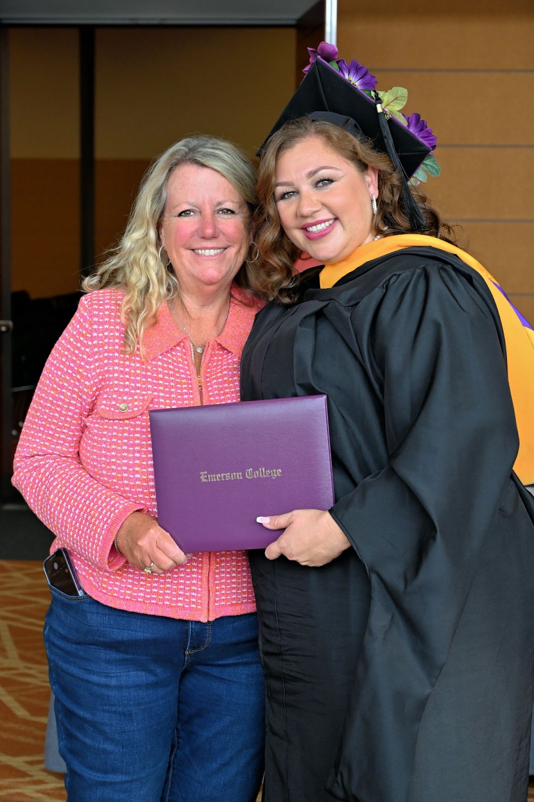 Graduate embraces woman with a smile.