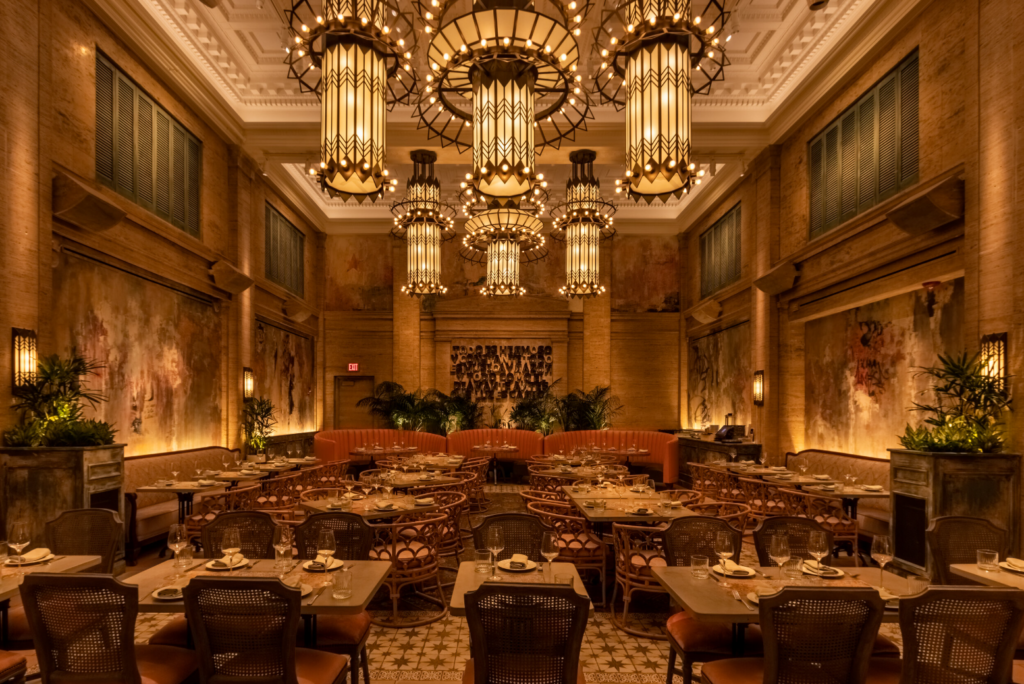 Interior of the lounge space in Mariel, with chairs, tables, and ambient lighting.