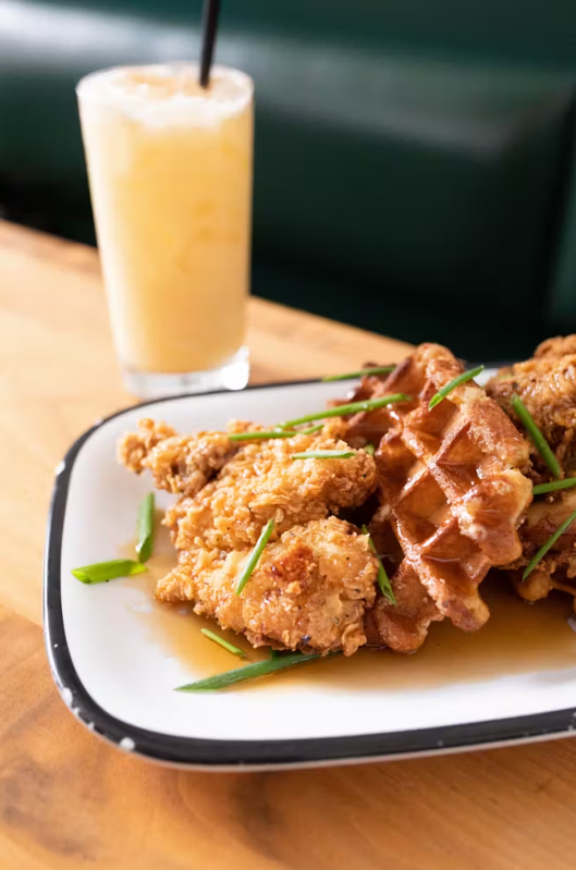 Chicken and waffles with syrup.