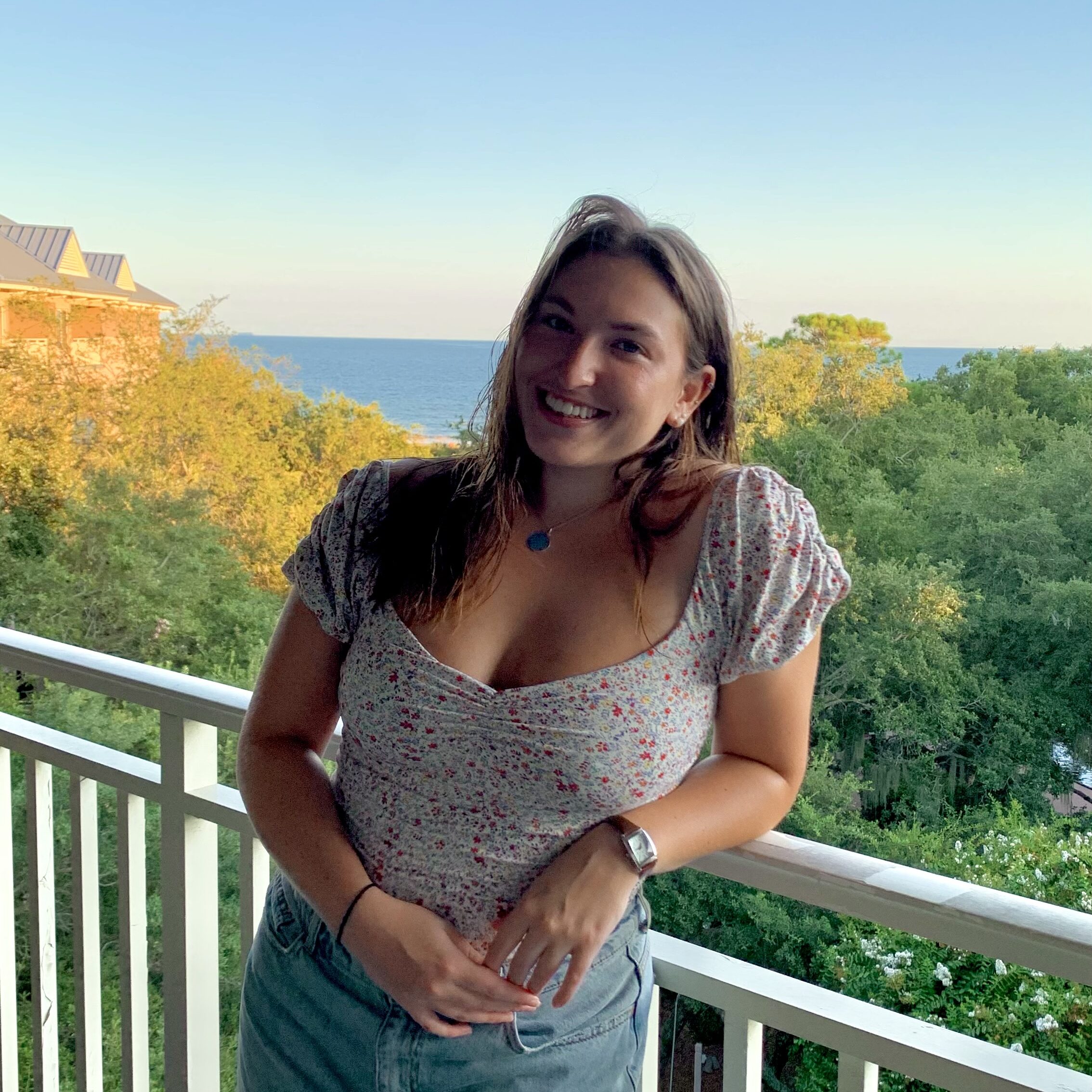 Lizzy DiGrande smiles at camera with nature in background.