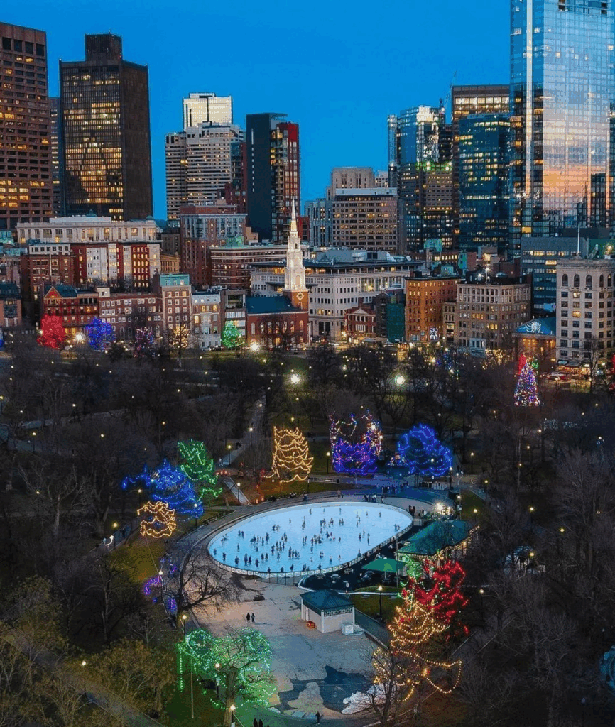 Aerial shot of Boston Common and the ice skating on Frog Pond, with a view of the Boston skyline in the background.