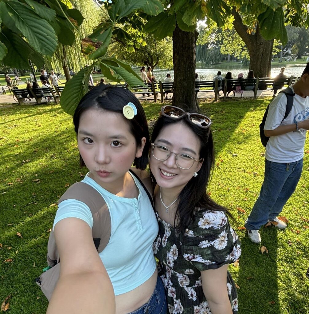 Rue and Star smile at the camera as they take a selfie outside on a sunny day.