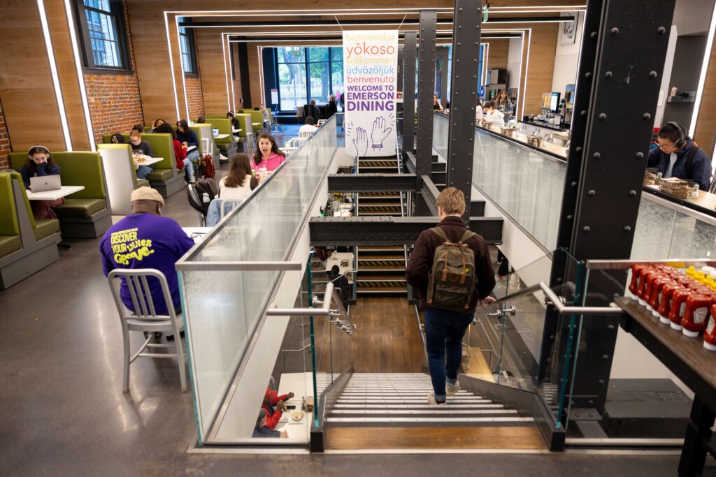 Emerson's dining hall, featuring green booths on the left and a staircase heading to the lower level.