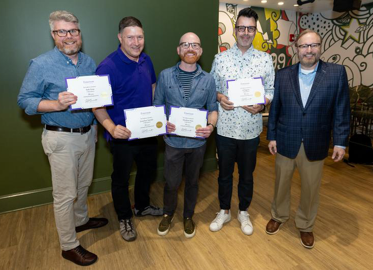 President Bernhardt poses with four staff members holding service certificates