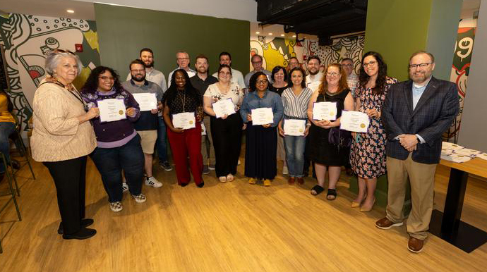 President Bernhardt poses with a group of staff members holding their service certificates