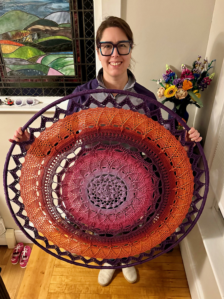 Liz Chase holding circular crochet artwork